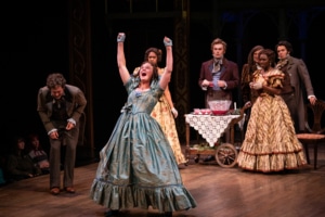 A woman raises her arms and shouts with joy in A Christmas Carol