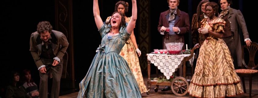 A woman raises her arms and shouts with joy in A Christmas Carol