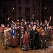 The cast of A Christmas Carol poses for a photo onstage
