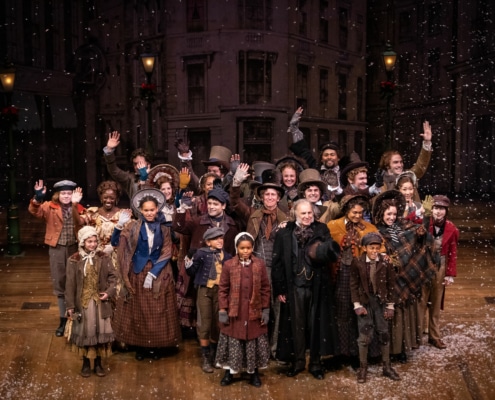 The cast of A Christmas Carol poses for a photo onstage