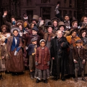 The cast of A Christmas Carol poses for a photo onstage