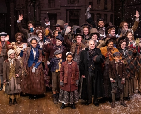 The cast of A Christmas Carol poses for a photo onstage