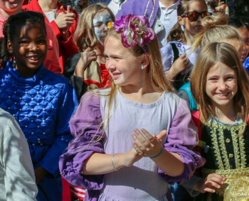 A group of elementary school-aged girls appear in costume at a community outreach event