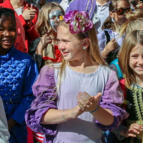 A group of elementary school-aged girls appear in costume at a community outreach event