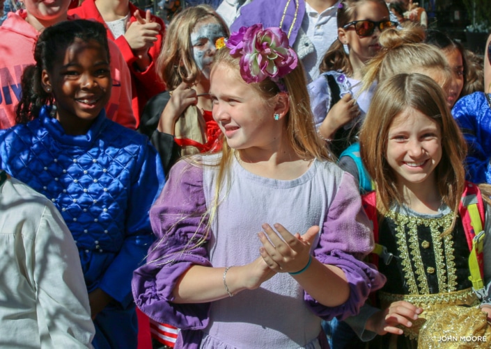 A group of elementary school-aged girls appear in costume at a community outreach event