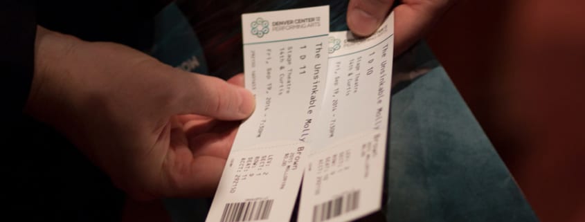 An individual holding a pair of tickets