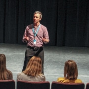Timothy McCracken Teaching Artist standing on stage addressing an audience