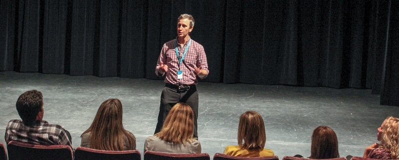 Timothy McCracken Teaching Artist standing on stage addressing an audience