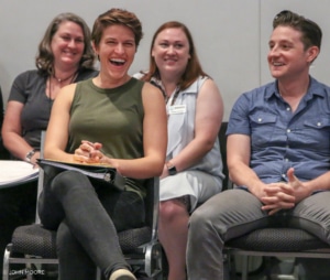 People seated in rows laugh and smile