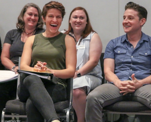 People seated in rows laugh and smile