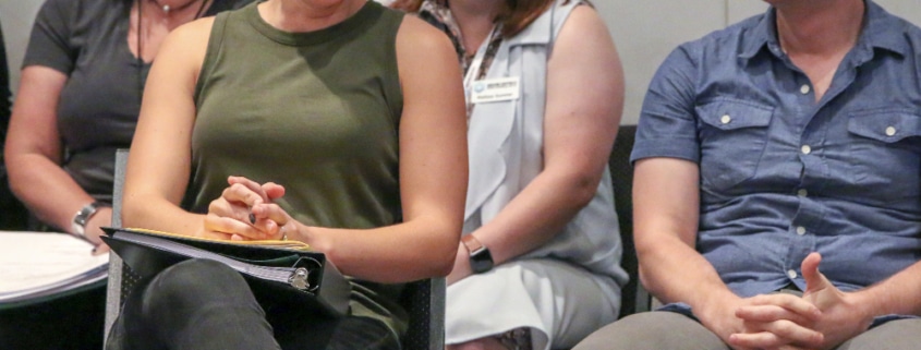 People seated in rows laugh and smile