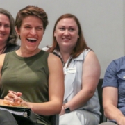 People seated in rows laugh and smile