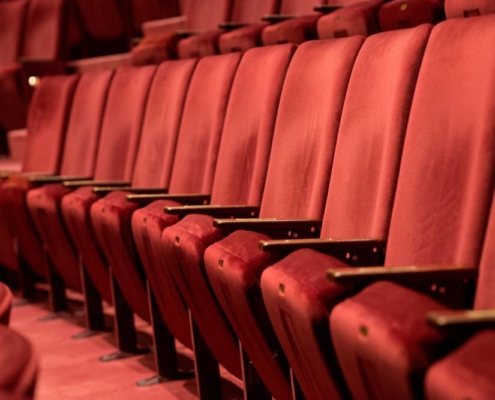 Donate your tickets View down a row of red theatre seats