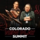 A graphic of two women rehearsing at the Colorado New Play Summit. One reads from a script, the other listens with arms crossed, conveying focus and collaboration. White and red text below reads "COLORADO NEW PLAY SUMMIT."