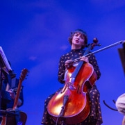 Singer playing cello on stage.