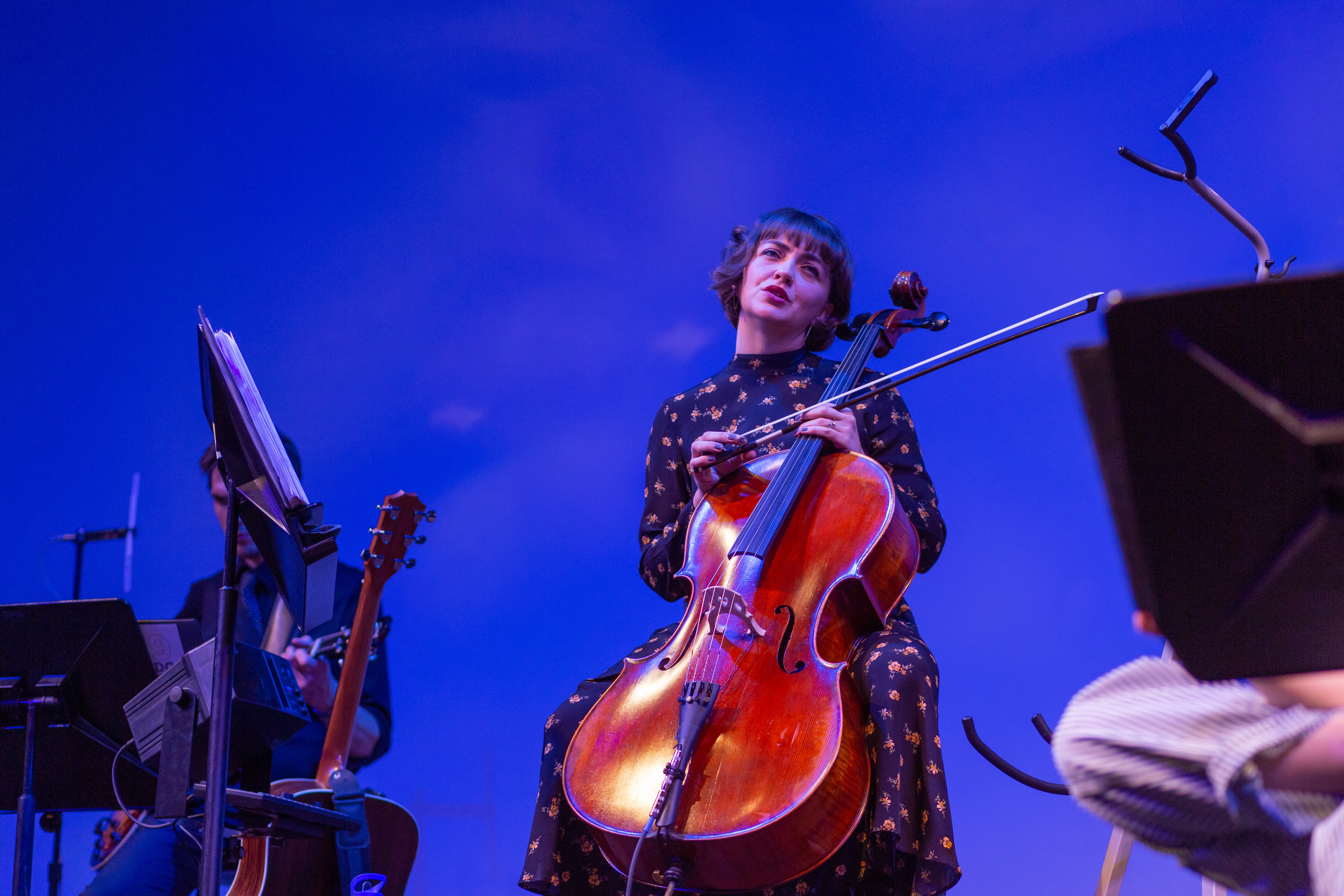 Singer playing cello on stage.