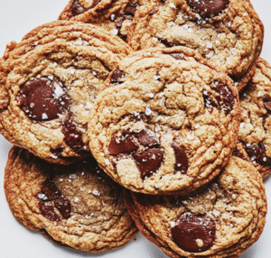 A stack of brown butter and toffee chocolate chip cookies garnished with kosher salt