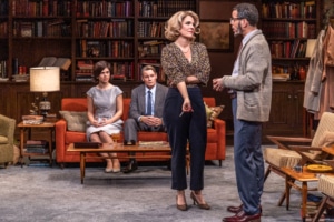 production photo of DCPA theatre company's who's afraid of virginia woolf. a man and woman stand in front of another man and woman sitting on a red couch.