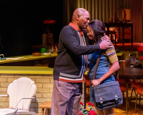 Levy Lee Simon, portraying Eddie, gives Courtney A. Vinson a hug and a kiss on the forehead during a performance of In The Upper Room