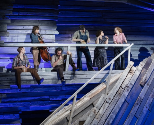 The cast of Rattlesnake Kate on a balcony onstage drinking moonshine