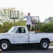 actor stands on pickup truck during Shakespeare in the Parking Lot performance