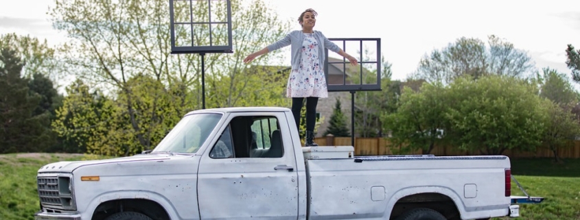 actor stands on pickup truck during Shakespeare in the Parking Lot performance