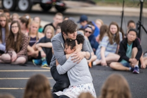 Actors embrace in Shakespeare in the Parking Lot production