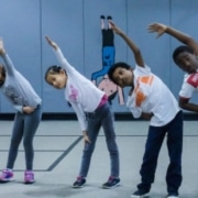 young dancers stretch while in a line at Cleo Parker Robinson Dance Academy