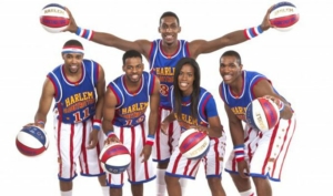 Harlem Globetrotters pose in uniform holding basketballs