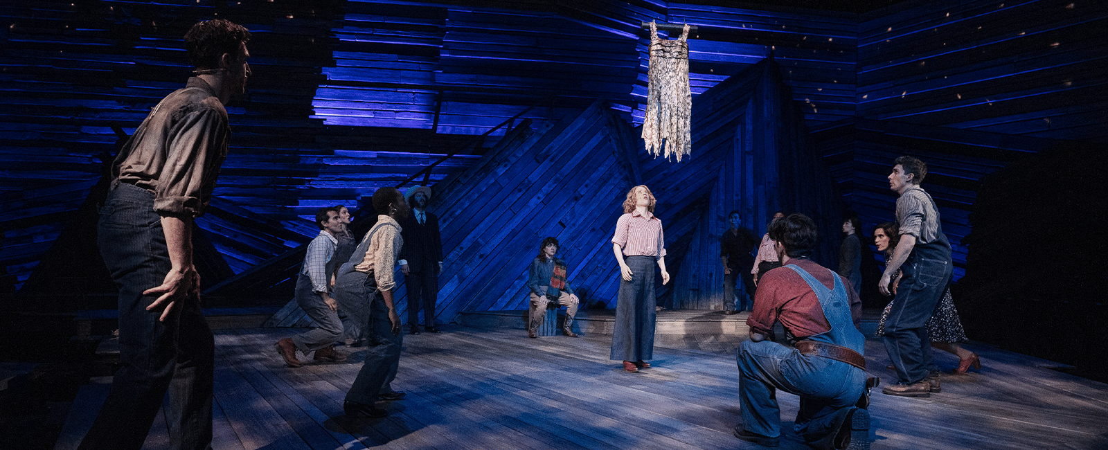 The cast of Rattlesnake Kate on stage with Alyse Alan Louis, portraying Kate, at center stage. All eyes are on the rattlesnake skin flapper suspended in mid-air.