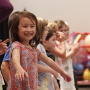 Children in acting class stand in a line, smiling