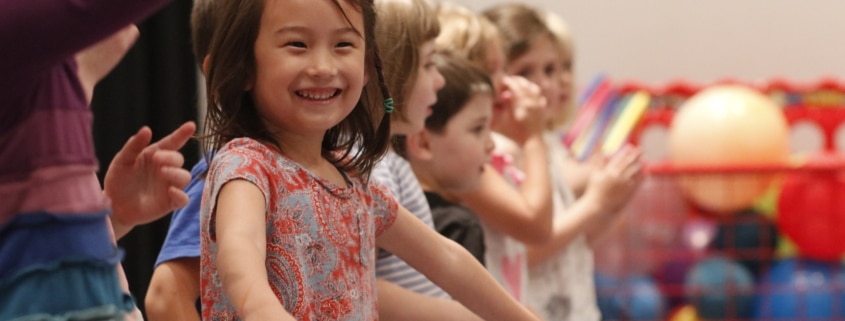 Children in acting class stand in a line, smiling