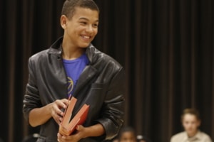 Teen actor stands in a class with a book in his hands