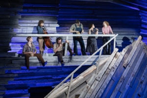 The cast of Rattlesnake Kate sits on a balcony on the set