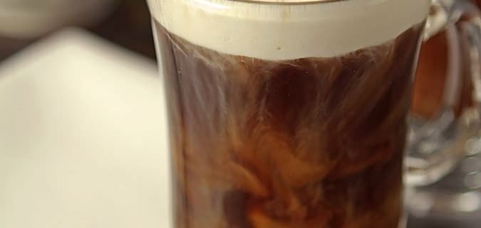 An irish coffee in a handled glass with chocolate shavings on top