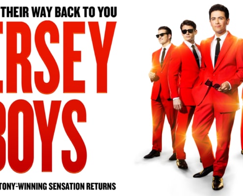 Promotional graphic for Jersey Boys featuring four performers in matching bright red suits and black ties against a white background. Large red text displays the show's title, while smaller text above and below notes the return of the Tony Award-winning musical. A gold emblem in the corner highlights the 20th anniversary tour.