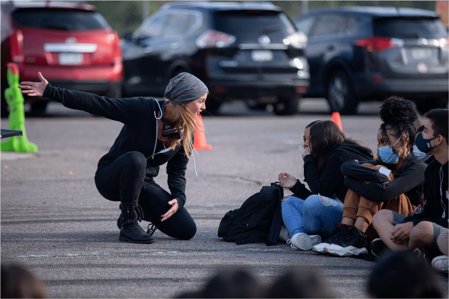 Actress kneels and gestures behind her as she converses with young audience member while they share laughter