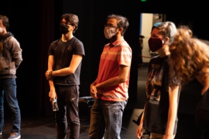 Students stand in a circle onstage in the Weeks Conservatory Theatre