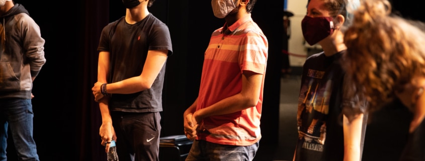 Students stand in a circle onstage in the Weeks Conservatory Theatre