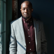 Jamil Jude wearing a suit in a dark room