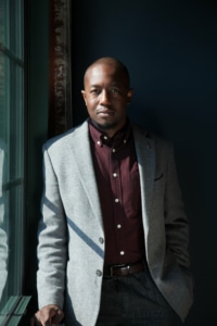 Jamil Jude wearing a suit in a dark room