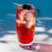 A Shirley Temple in a glass filled with ice and topped with cherries