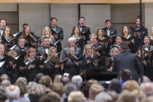 The Kantorei choir holds music books while singing onstage