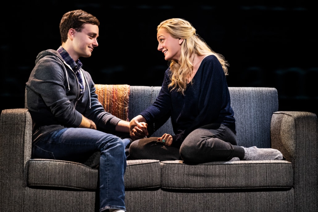 Stephen Christopher Anthony as Evan Hansen sits on a couch with Jessica E. Sherman as Heidi Hansen