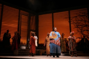 A group of women dressed in traditional African clothing sing onstage in The Color Purple.