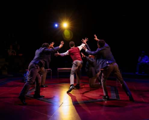 The cast of Choir Boys hold their hands up towards the audience