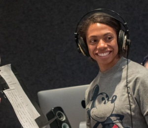 An actor in a DCPA Education voice over class wears headphones and smiles