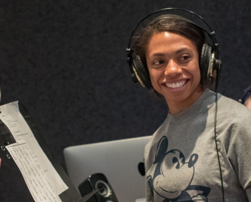 An actor in a DCPA Education voice over class wears headphones and smiles