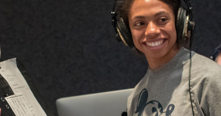 An actor in a DCPA Education voice over class wears headphones and smiles