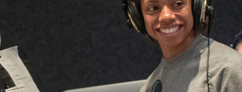 An actor in a DCPA Education voice over class wears headphones and smiles